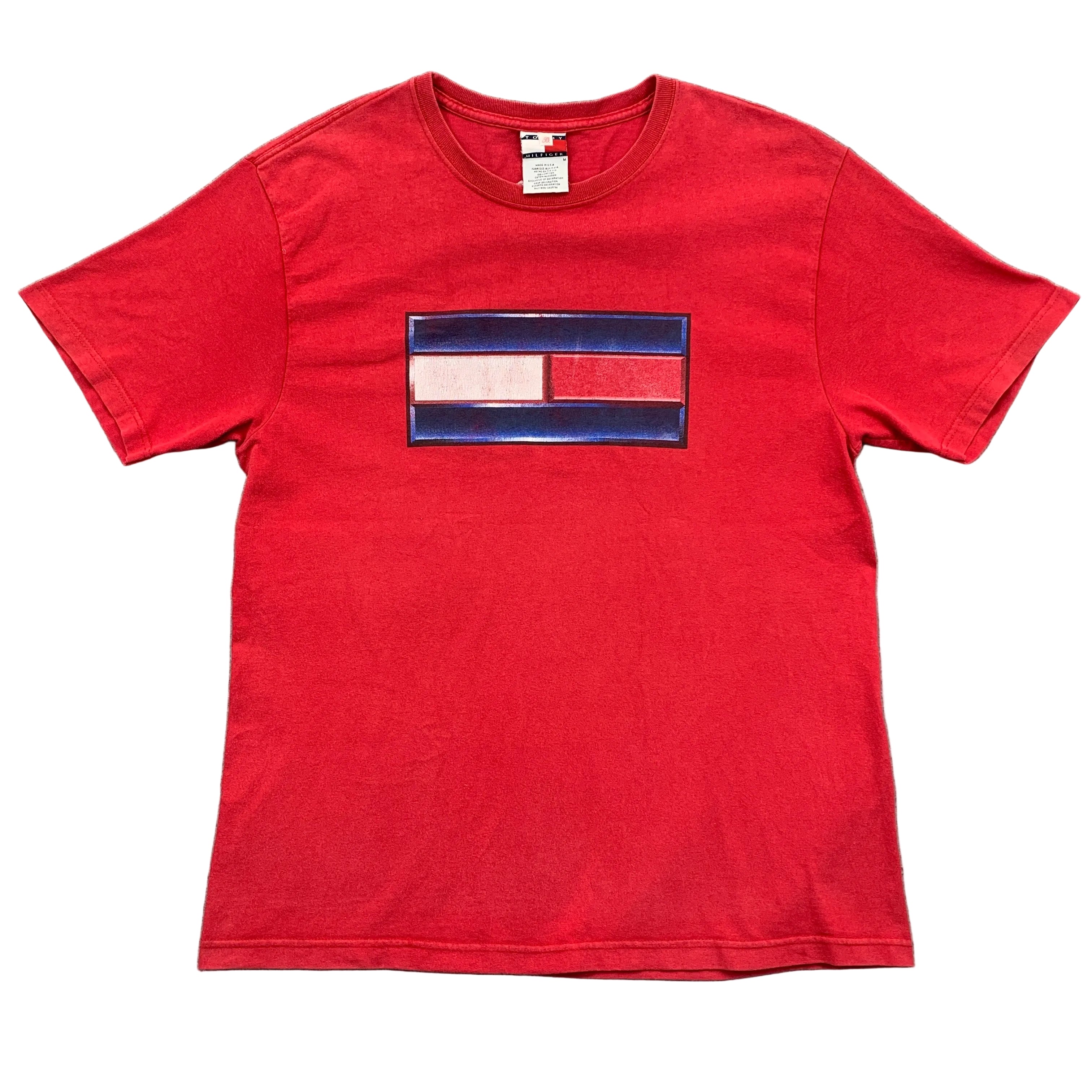Red t-shirt with a graphic design on a gray surface