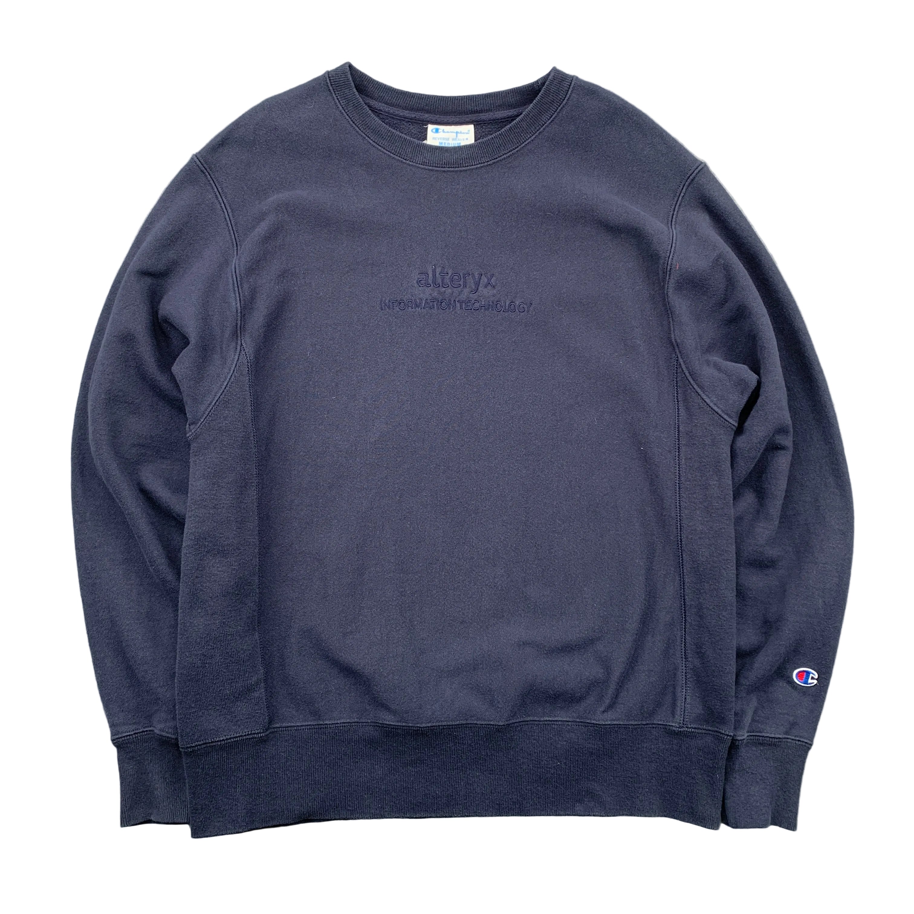 Navy blue sweatshirt with branding on a gray surface