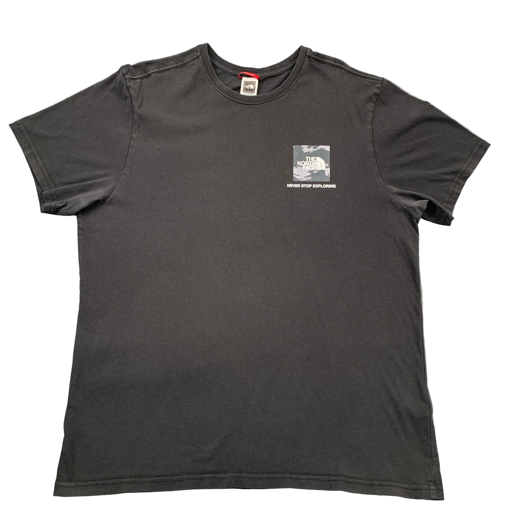 Black t-shirt with a small graphic on a gray surface