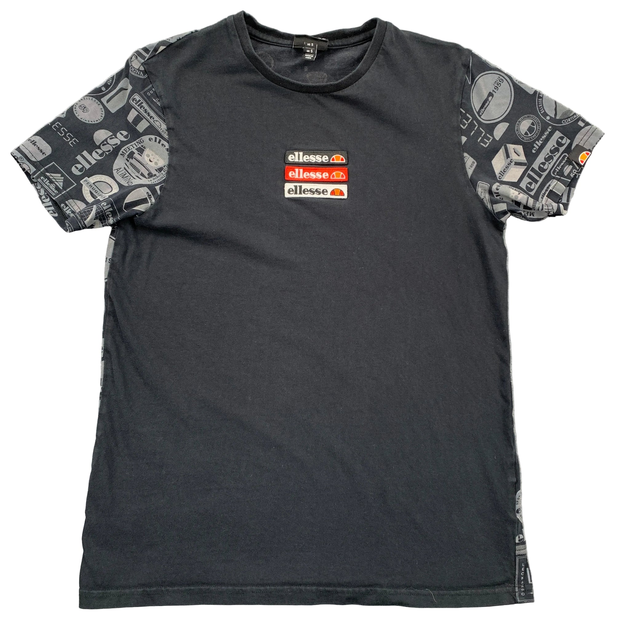 Black t-shirt with patterned sleeves and Ellesse logo on a gray surface