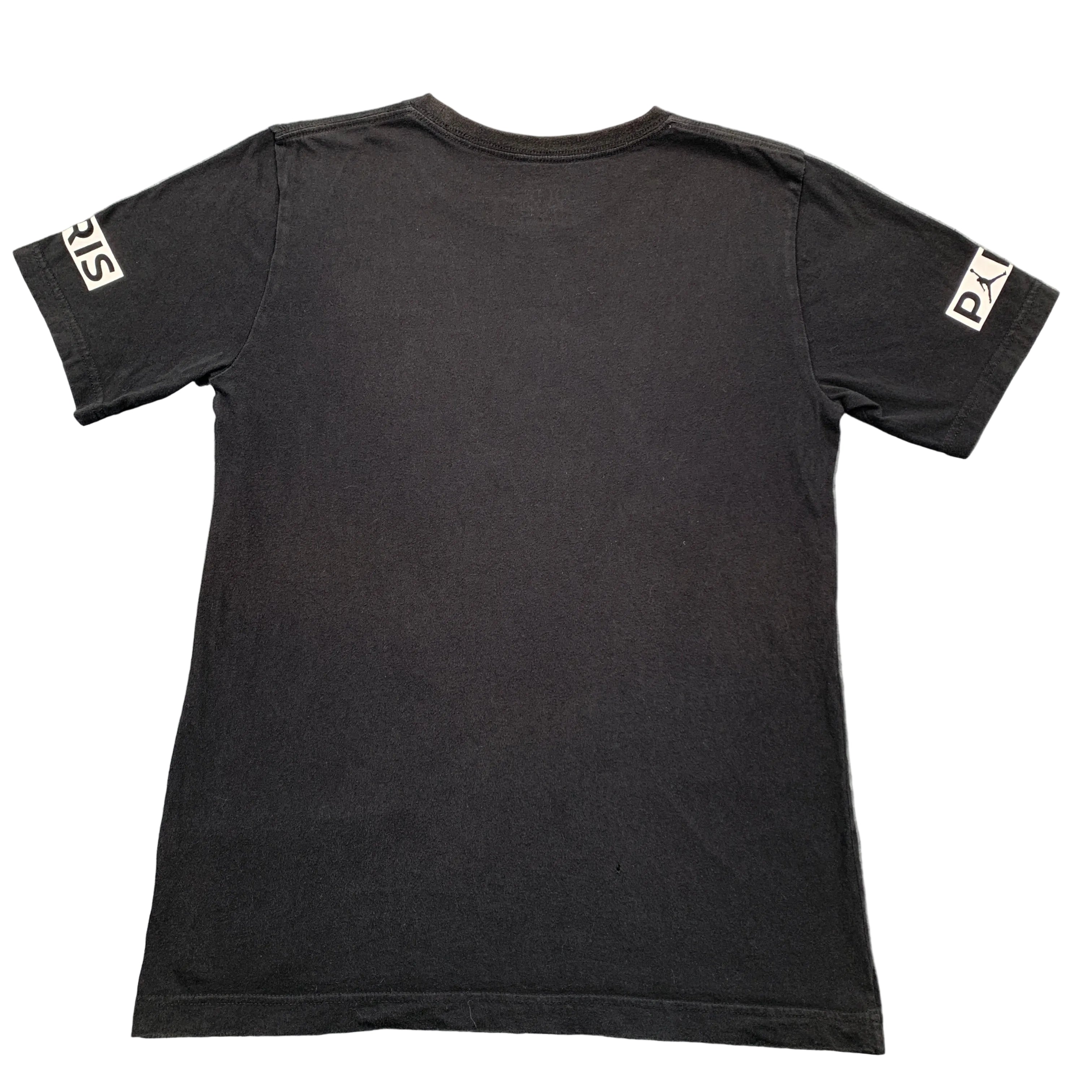 Black t-shirt with brand logos on sleeves against a gray background