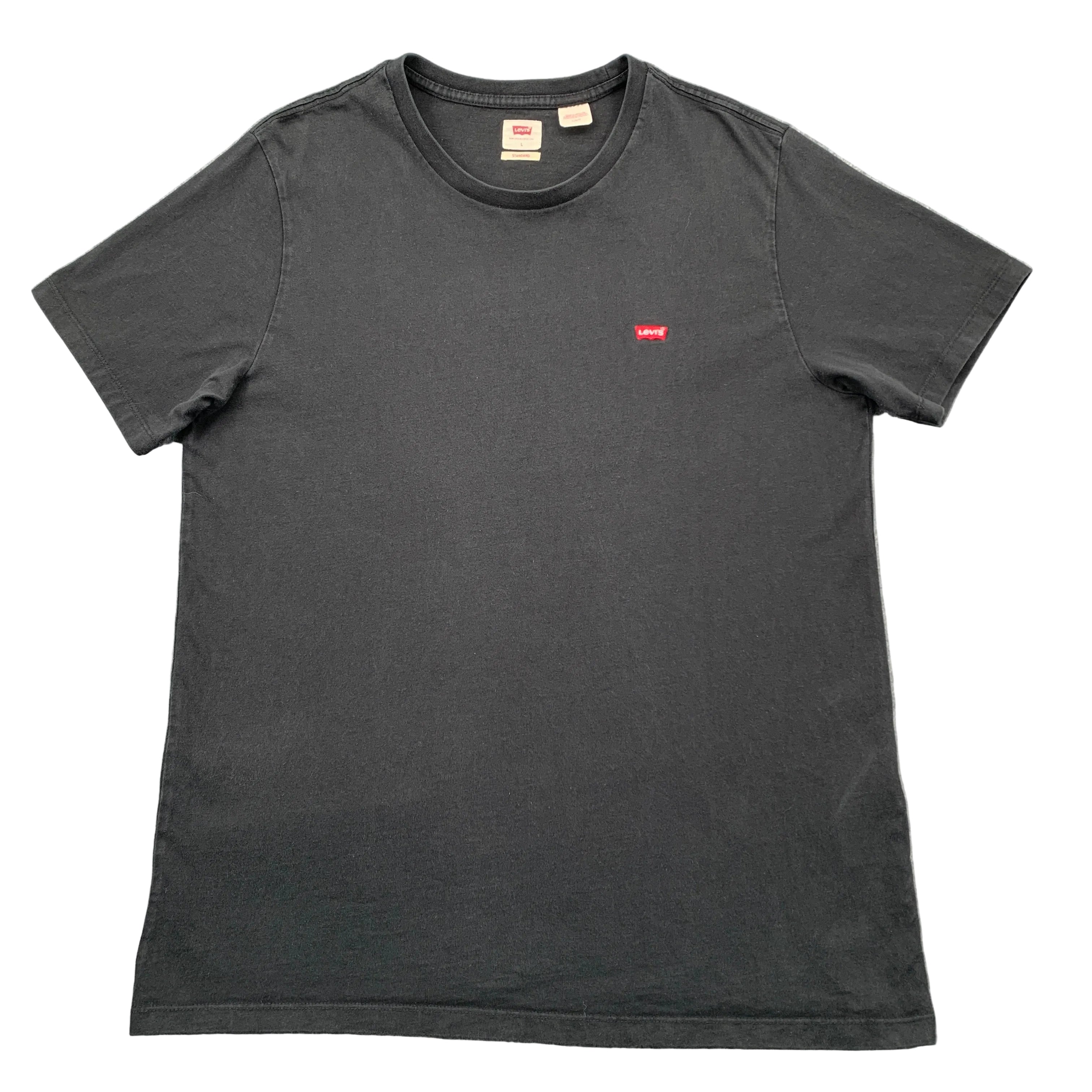 Black t-shirt with a small red logo on a gray textured background