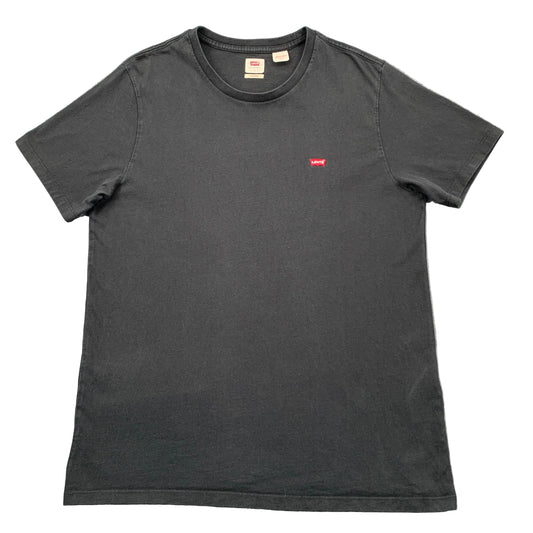 Black t-shirt with a small red logo on a gray textured background