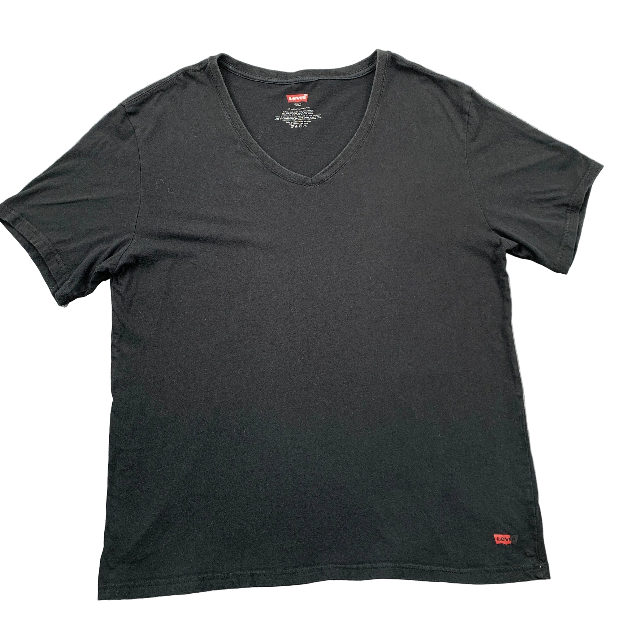 Black t-shirt with brand logo on a gray surface
