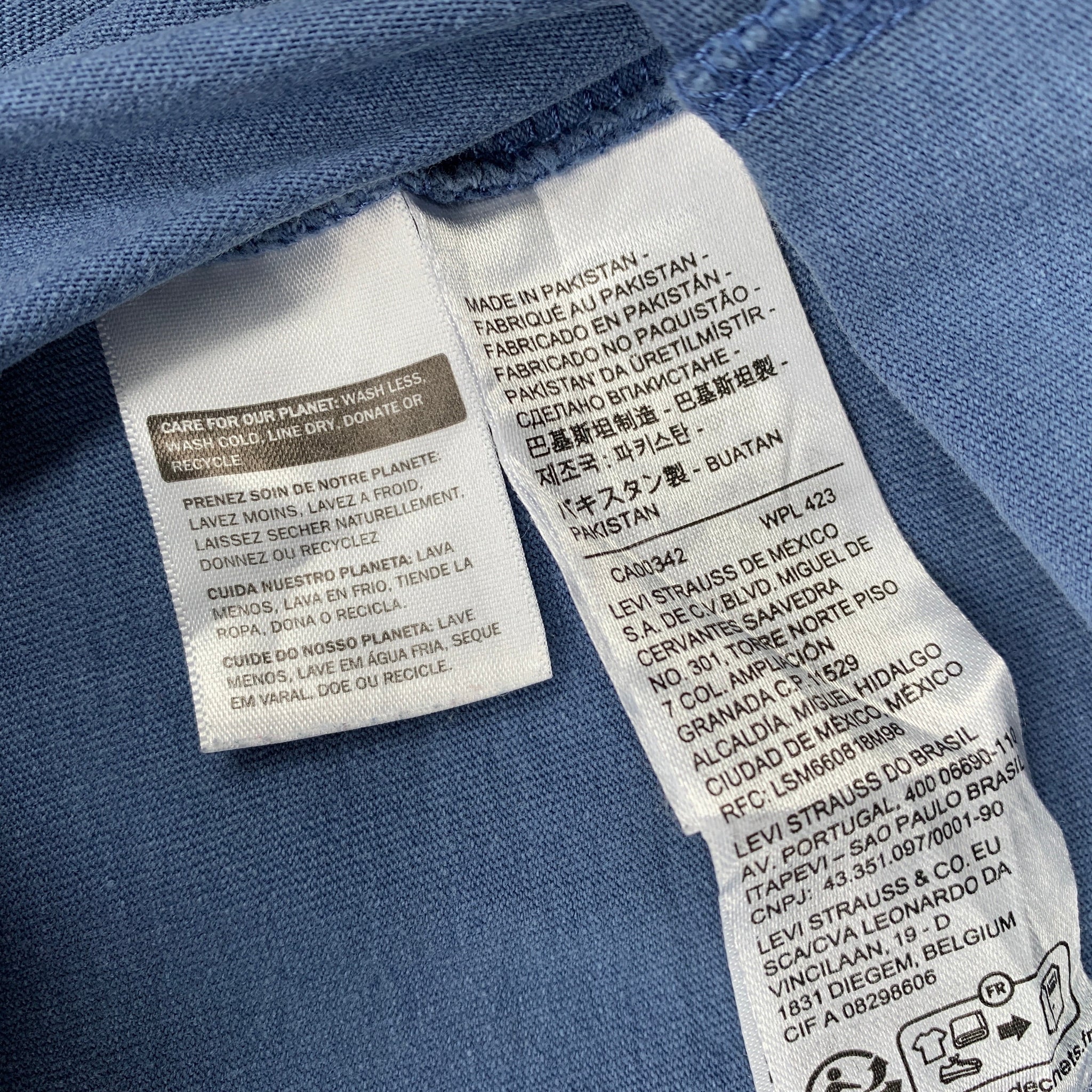 Close-up of fabric labels on a blue garment with text and symbols.