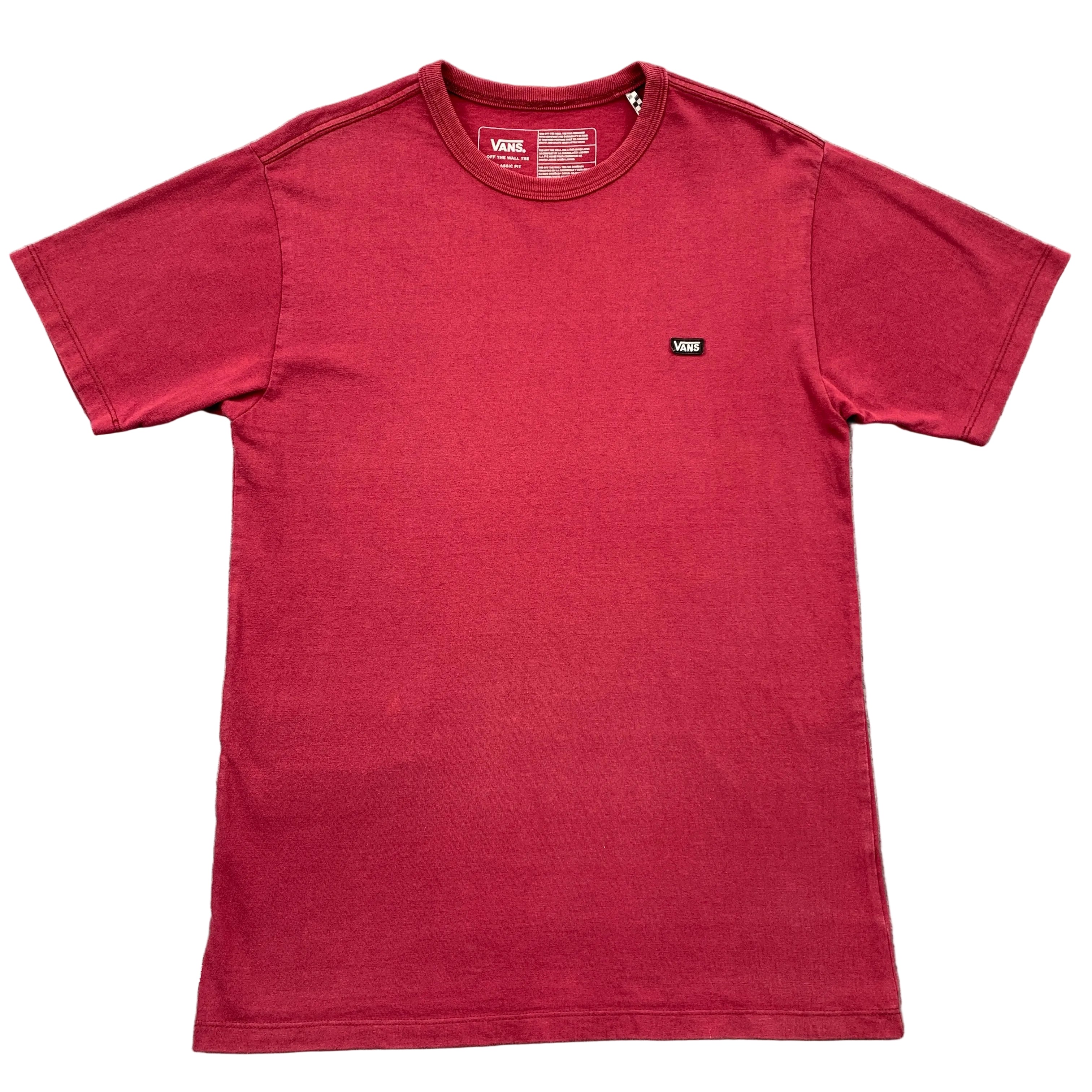 Red t-shirt with a small logo on a gray textured surface