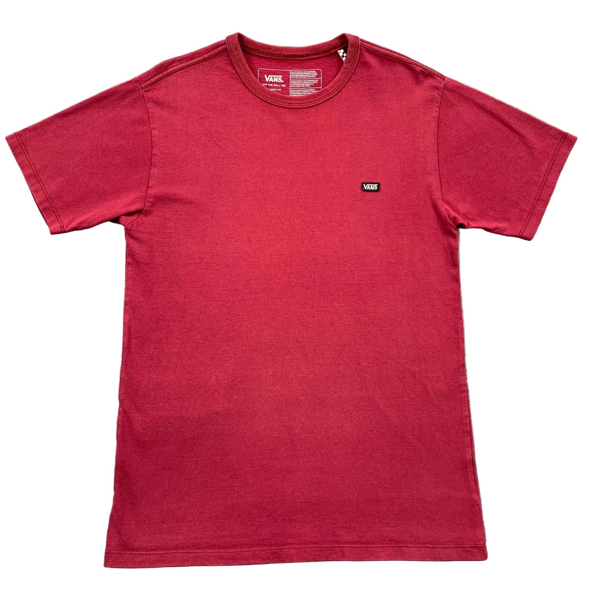 Red t-shirt with a small logo on a gray textured surface