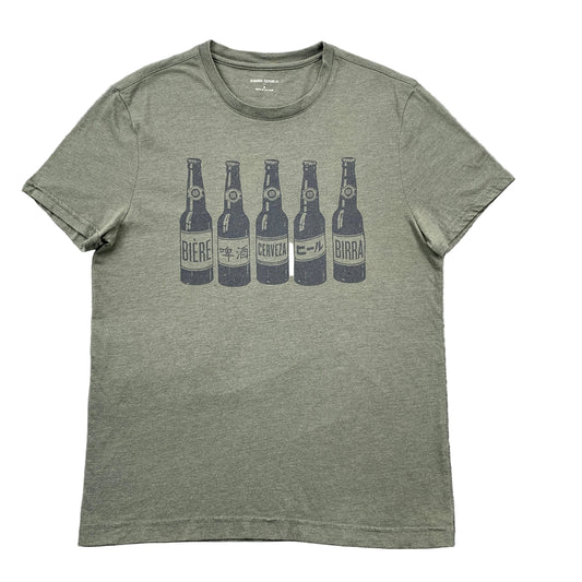 Green t-shirt with beer bottle graphic on a gray surface