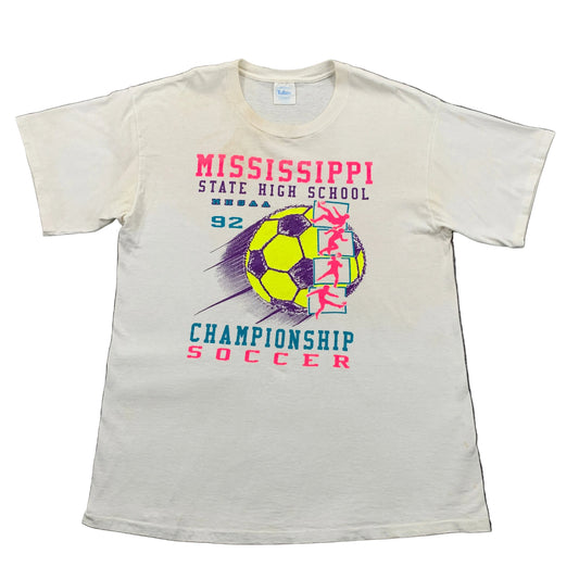 White t-shirt with Mississippi State High School championship soccer design on a gray surface
