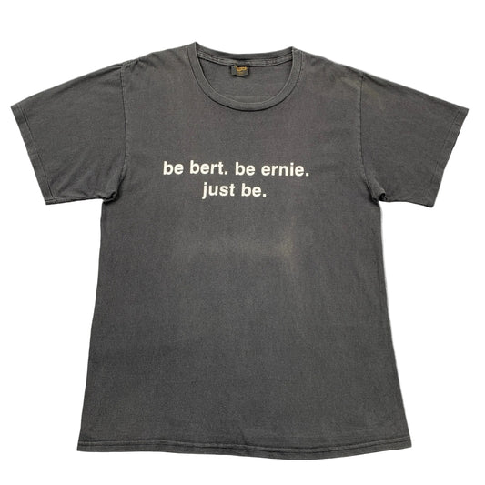 Gray t-shirt with white text on a gray surface