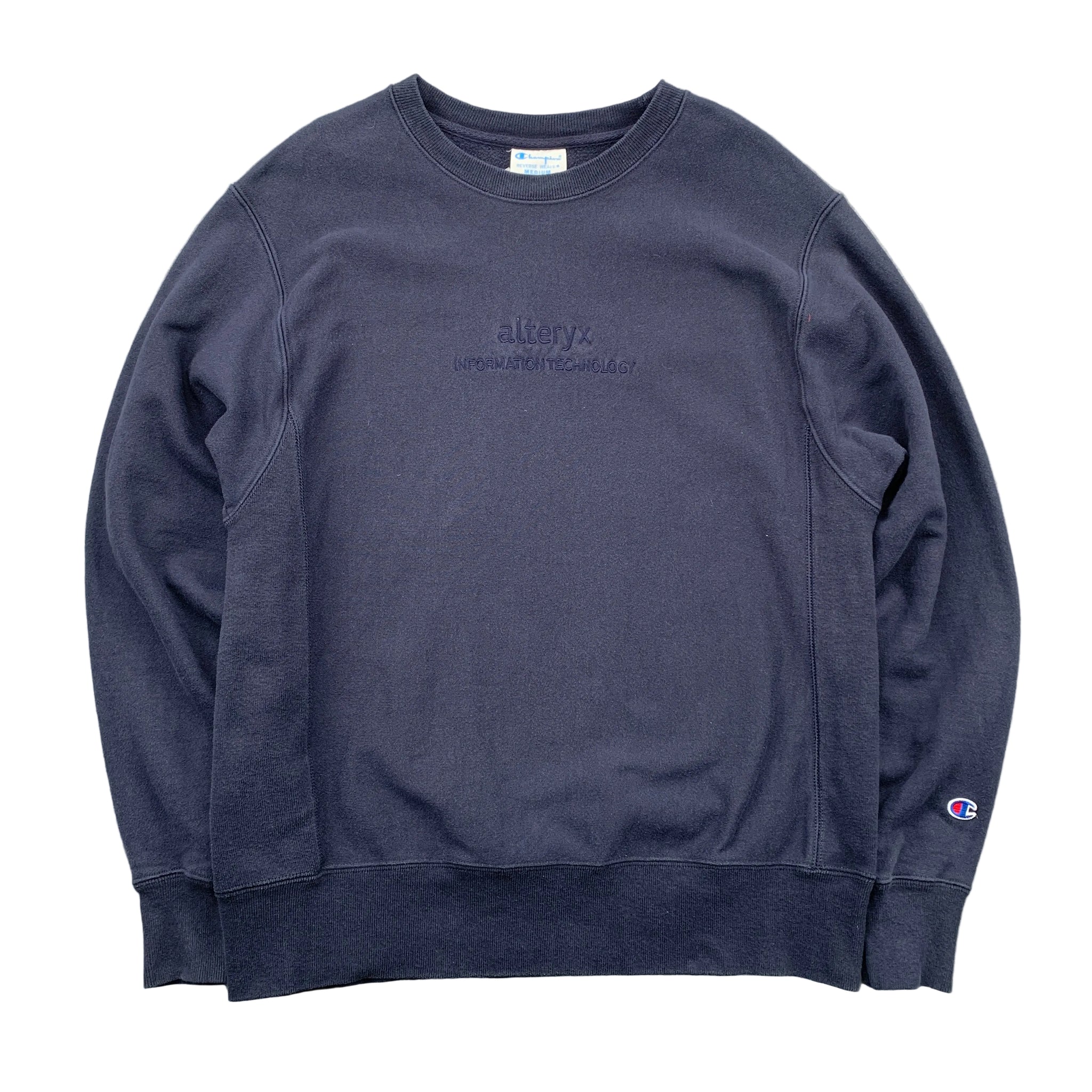 Navy blue sweatshirt with branding on a gray surface